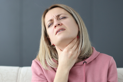 Woman-suffered-in-Voice-Hoarseness Woman-in-pink-hold-her-throat-feeling-uncomfortable